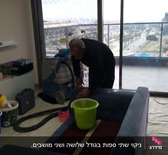 אדם מנקה ספה עם דלי ירוק ושואב אבק